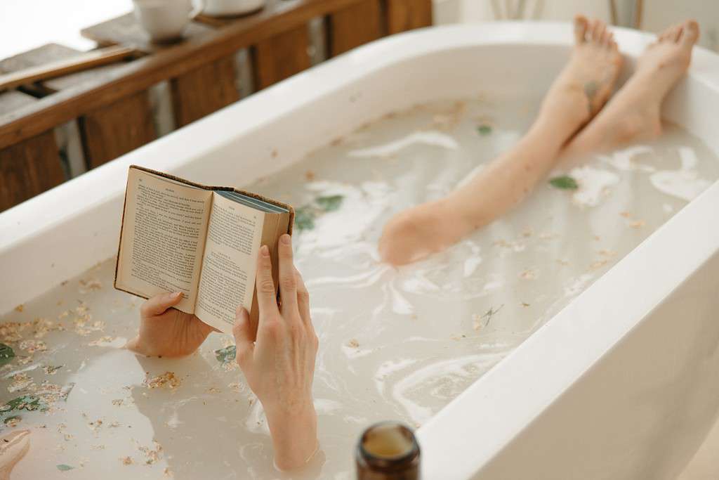 Bathing while reading a book. Ultimate self-care and rejuvenating practice