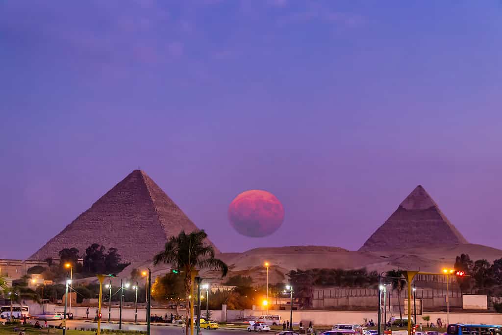 View of the great pyramids of Giza at sunset from Giza city with big full moon rising